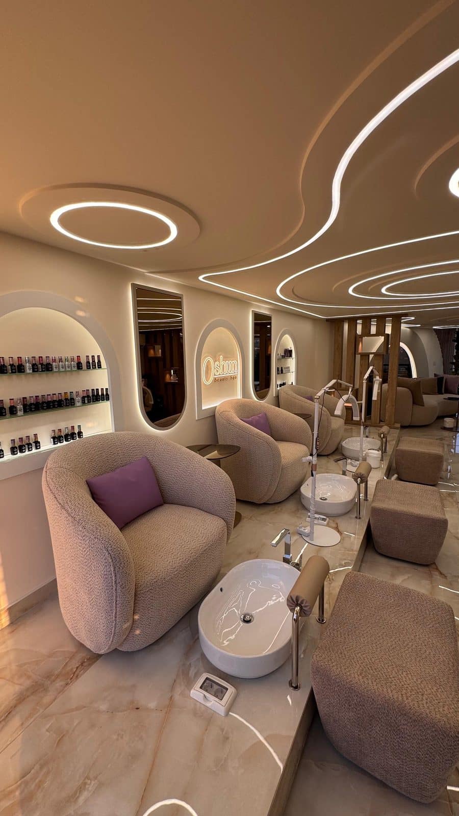 The cream lounge inside Oshun Beauty Spa, with arched alcoves and a sculptural lit ceiling